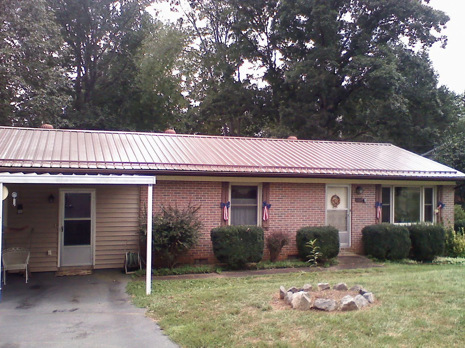 Bronze metal roof and carport on a brick ranch home — Roof Repair work by our crew in Carle Place